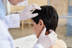 Chiropractor examining a patient's neck for spinal alignment and potential subluxations during a chiropractic adjustment.