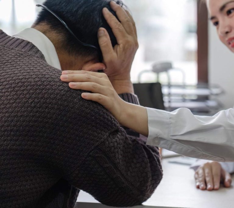 Chiropractor comforting a patient experiencing pain; a supportive approach to chiropractic care.