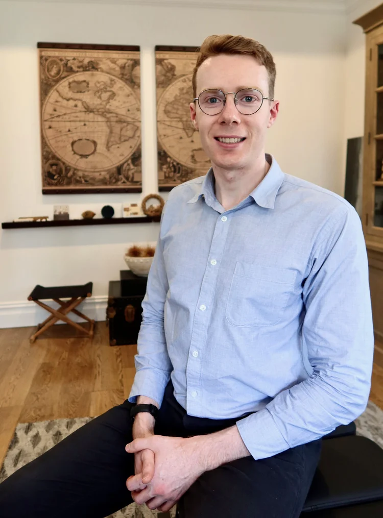 Portrait of a smiling chiropractor in his office, ready to provide chiropractic treatment and spinal adjustments.
