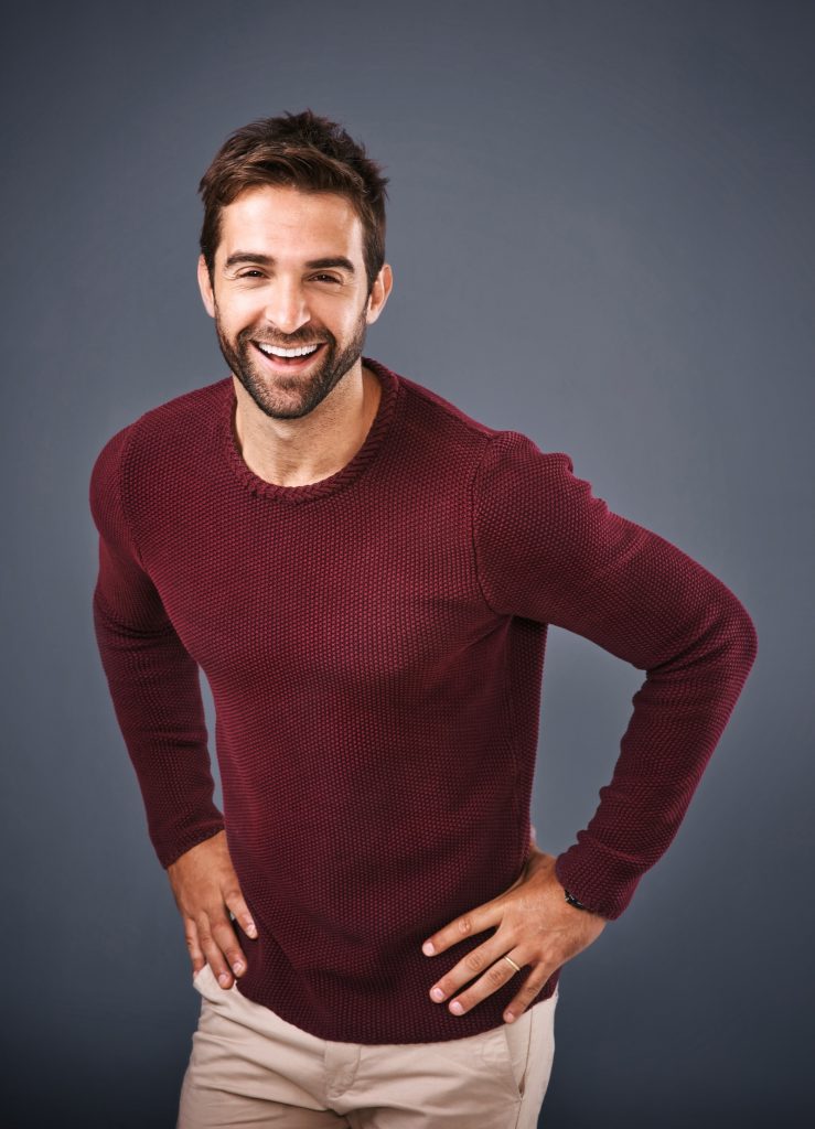 Smiling man feeling great after chiropractic adjustment demonstrating improved posture and well-being.