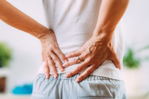 Woman suffering from lower back pain, potentially seeking chiropractic treatment for relief.