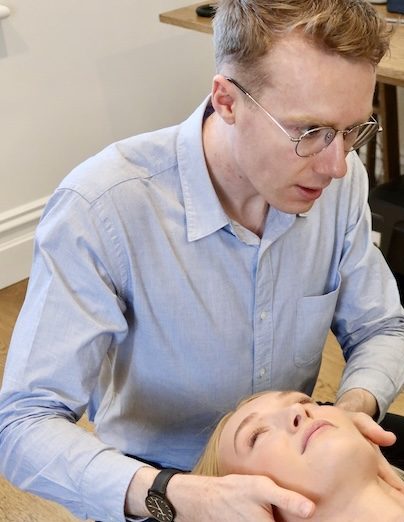 Chiropractor adjusting a patient's neck during a chiropractic treatment session.