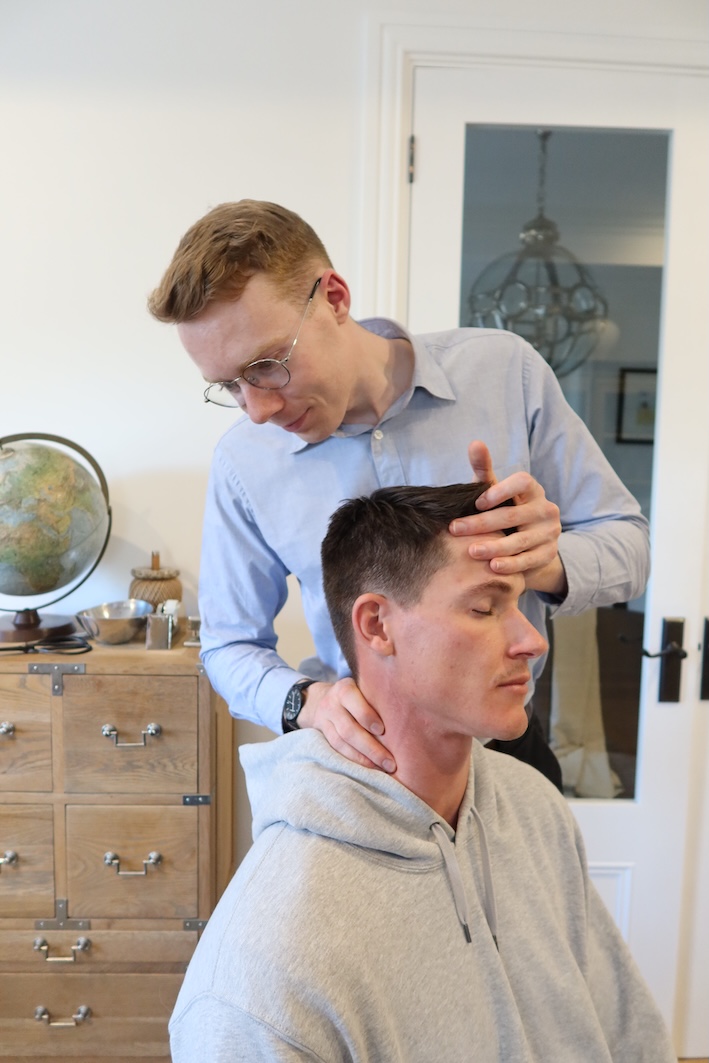 Chiropractor performing cervical adjustment on patient to relieve neck pain.